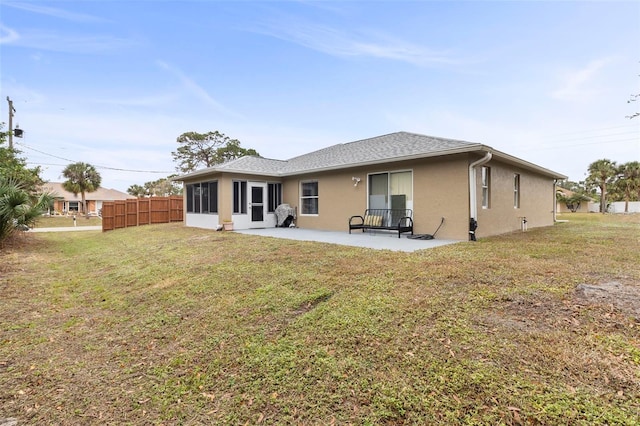 back of property with a yard and a patio area