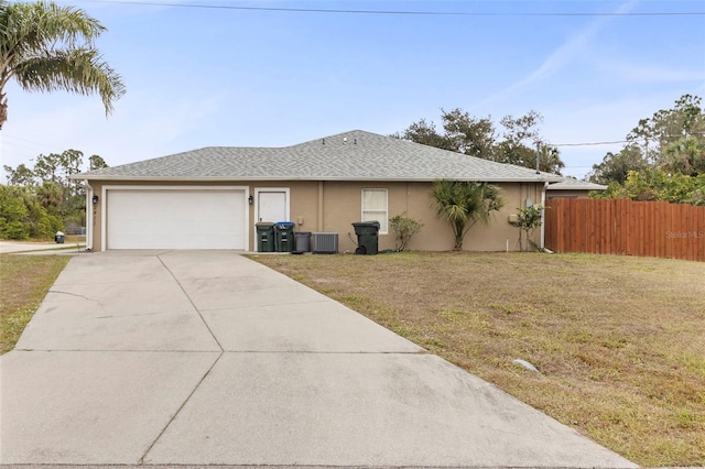 view of side of property with a lawn, central AC, and a garage