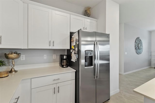 kitchen featuring light tile patterned floors, white cabinets, and stainless steel fridge