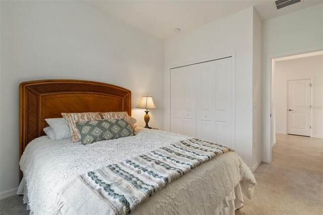 bedroom featuring light carpet and a closet