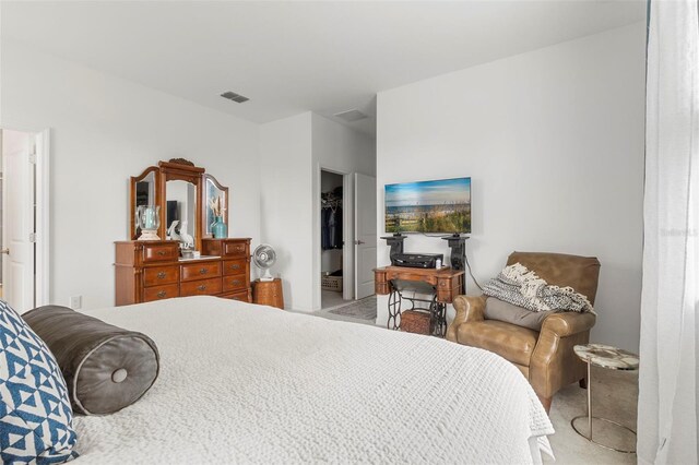 carpeted bedroom featuring a spacious closet and a closet