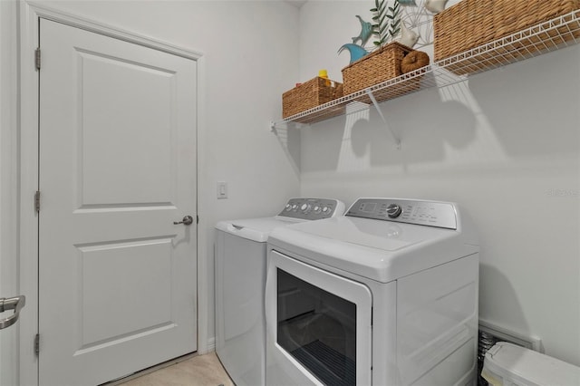 clothes washing area with washing machine and dryer