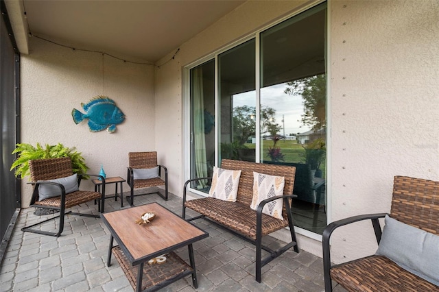 balcony with an outdoor hangout area and a patio