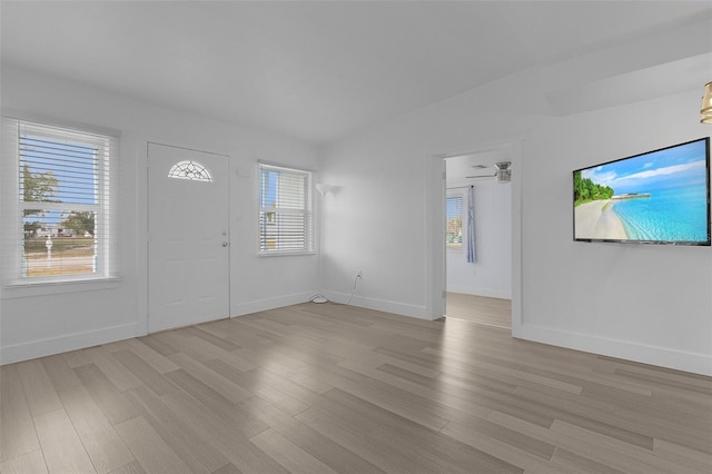 entrance foyer featuring light wood finished floors, plenty of natural light, and baseboards