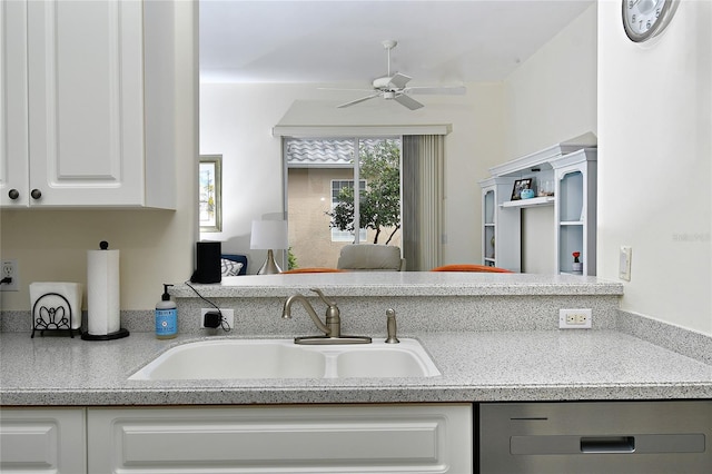 kitchen with ceiling fan, white cabinetry, and sink