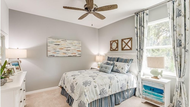 bedroom with light colored carpet, ceiling fan, and multiple windows