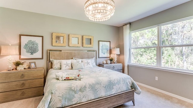 bedroom with a notable chandelier, light carpet, and multiple windows