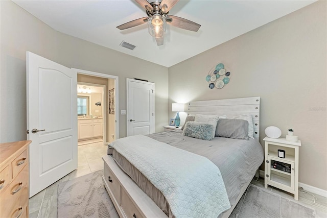 bedroom with ceiling fan, connected bathroom, and light tile patterned floors