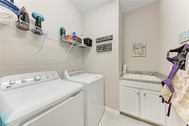 clothes washing area with sink, light tile patterned flooring, and washer and dryer