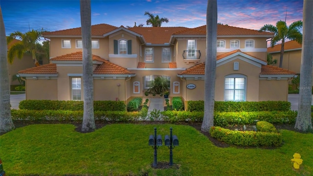 exterior space featuring a lawn and a balcony