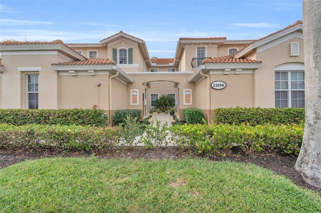 mediterranean / spanish home featuring a front yard