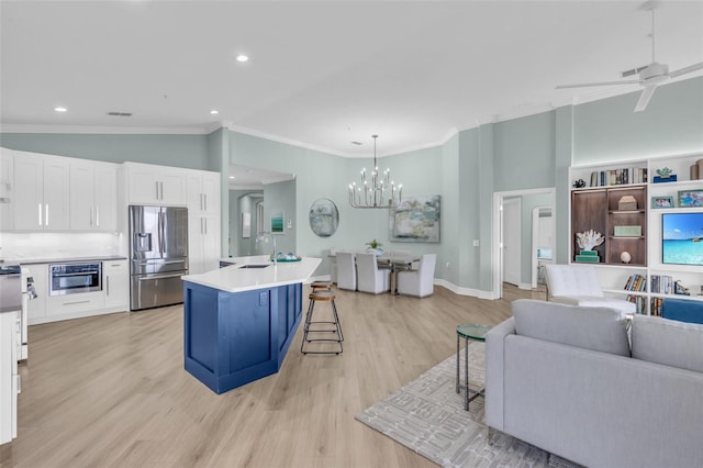 kitchen with pendant lighting, a breakfast bar, a kitchen island with sink, white cabinets, and stainless steel fridge with ice dispenser