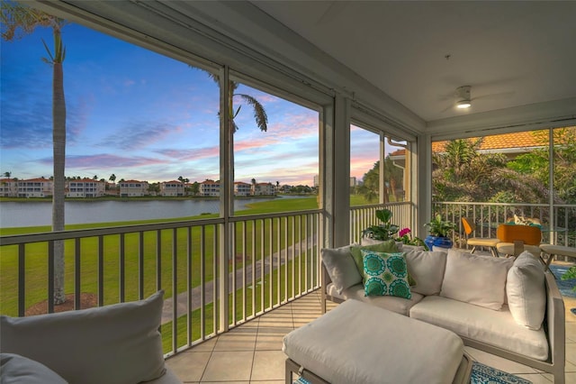 sunroom featuring a water view