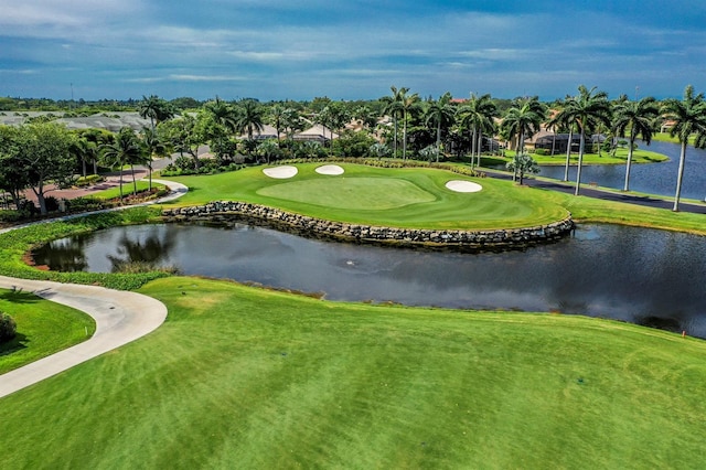 surrounding community with a water view and a lawn