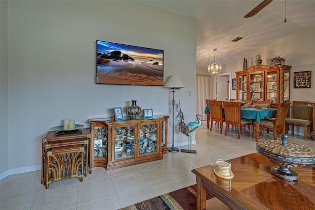 living room with vaulted ceiling, ceiling fan with notable chandelier, and light tile patterned floors