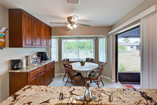 tiled dining area featuring ceiling fan and a textured ceiling