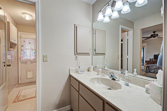 bathroom with vanity, ceiling fan, and a textured ceiling