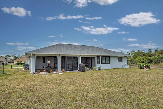 rear view of property with a yard and a sunroom