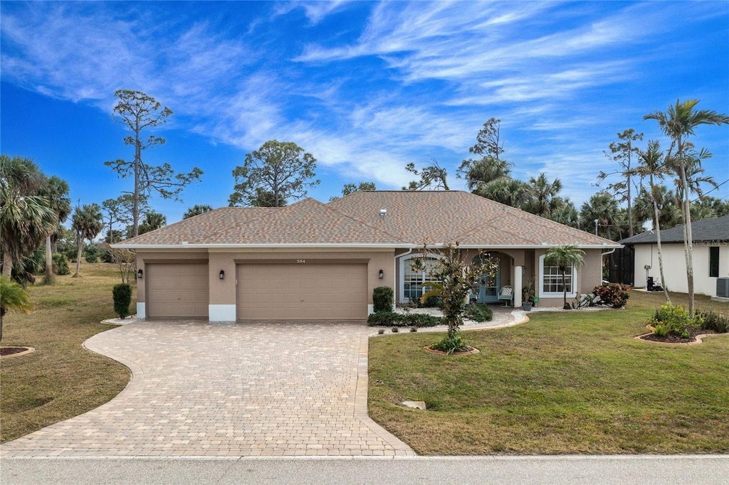 single story home featuring a garage and a front yard