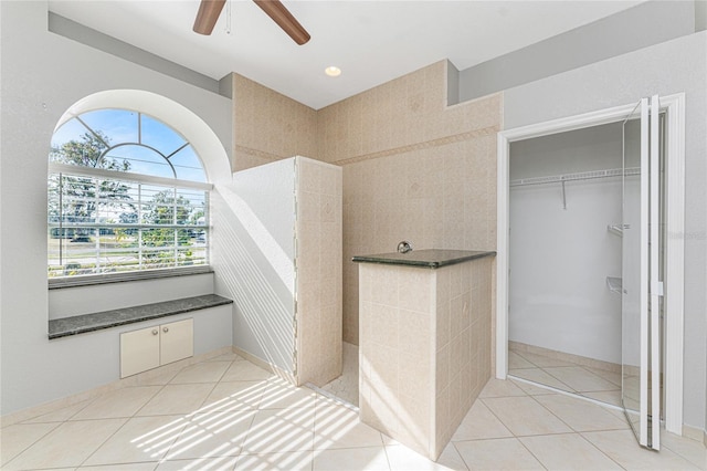 bathroom with a tile shower, tile patterned floors, and ceiling fan