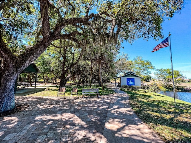 surrounding community featuring a yard, a water view, and an outbuilding