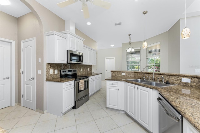 kitchen featuring appliances with stainless steel finishes, white cabinetry, hanging light fixtures, sink, and dark stone counters