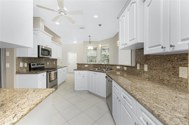 kitchen with pendant lighting, white cabinetry, stainless steel appliances, sink, and stone countertops