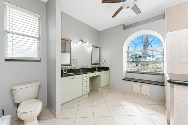 bathroom with vanity, toilet, a wealth of natural light, and tile patterned floors