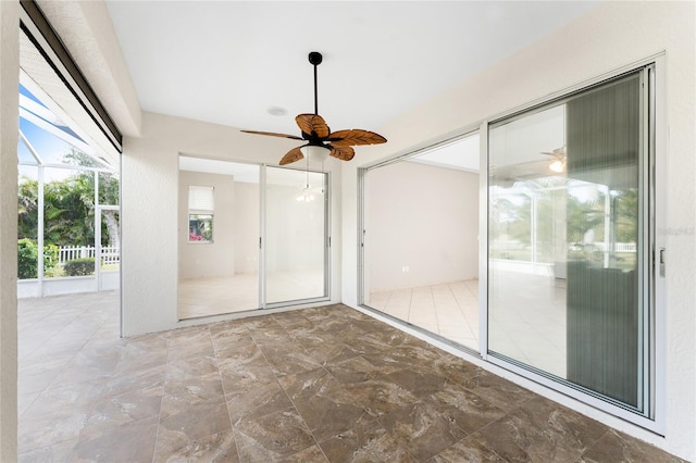 unfurnished sunroom with ceiling fan