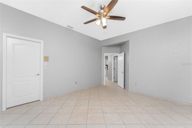 tiled empty room featuring ceiling fan