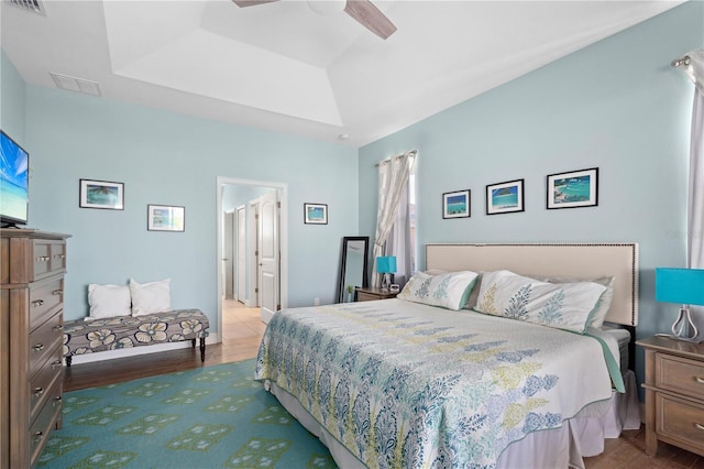 bedroom featuring hardwood / wood-style flooring, ceiling fan, and a tray ceiling