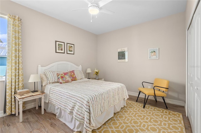 bedroom featuring ceiling fan, wood-type flooring, and a closet