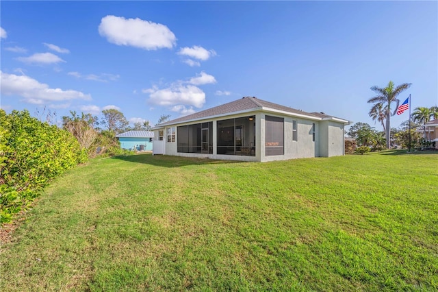 back of house with a yard and a sunroom