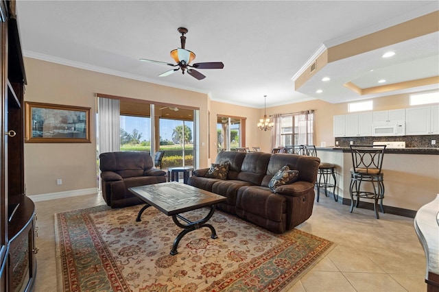 tiled living room with ceiling fan with notable chandelier, a raised ceiling, and ornamental molding