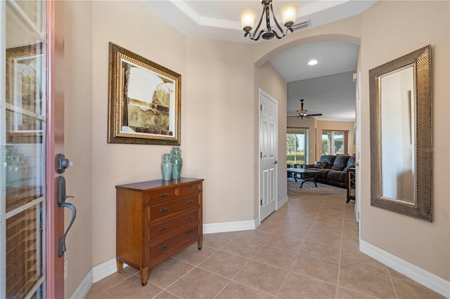 hallway featuring an inviting chandelier and light tile patterned floors