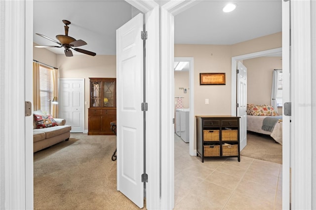 corridor with washer / dryer and light carpet