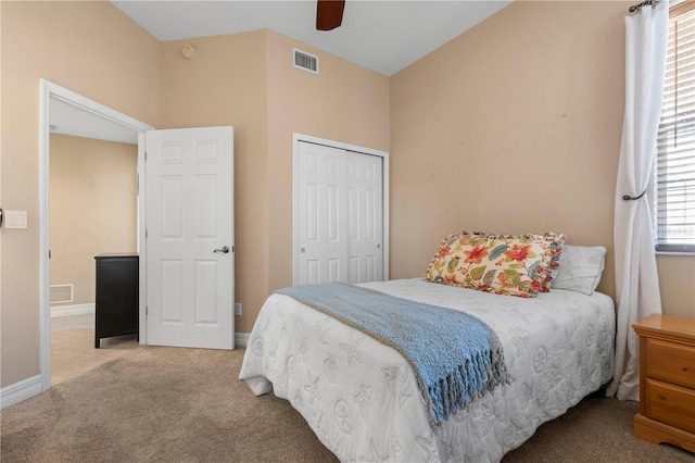 carpeted bedroom featuring ceiling fan and a closet