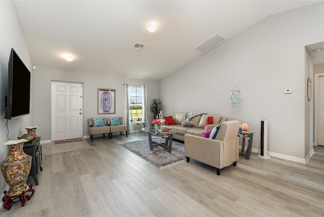 living room with light hardwood / wood-style floors and vaulted ceiling