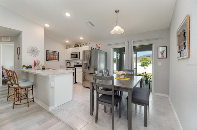 dining room featuring vaulted ceiling and sink