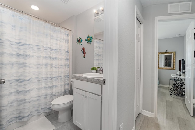 bathroom featuring toilet, hardwood / wood-style flooring, curtained shower, and vanity