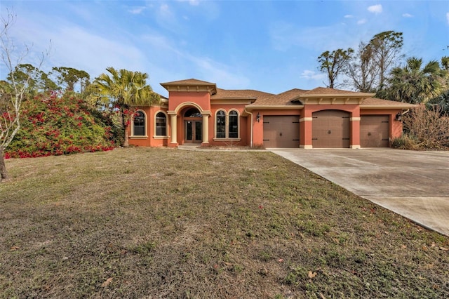 mediterranean / spanish-style house featuring a garage and a front yard