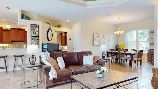 living room featuring sink, a notable chandelier, and light tile patterned flooring