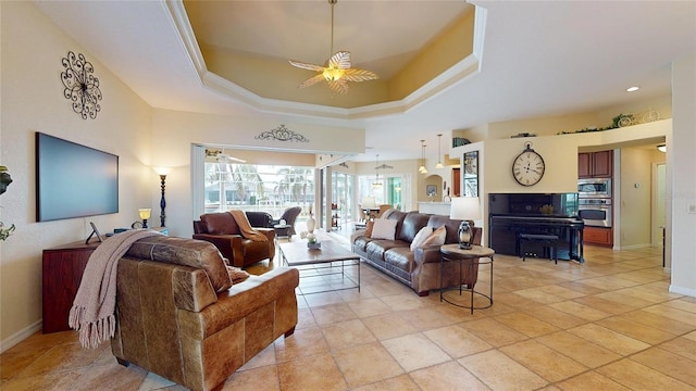 living room with ceiling fan, crown molding, and a tray ceiling