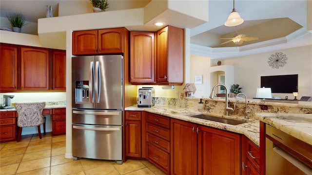 kitchen with stainless steel refrigerator with ice dispenser, ceiling fan, a tray ceiling, decorative light fixtures, and sink