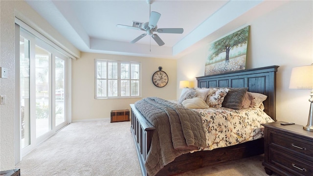 carpeted bedroom featuring ceiling fan, a raised ceiling, access to outside, and french doors