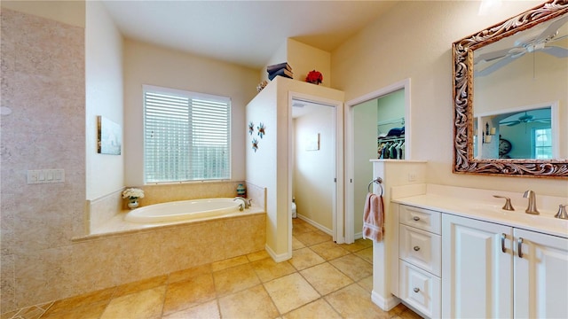 bathroom with toilet, vanity, and a relaxing tiled tub