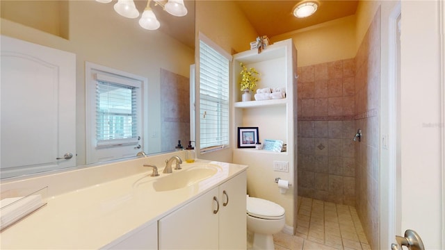 bathroom featuring toilet, a tile shower, tile patterned floors, and vanity