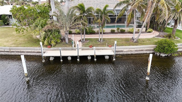 dock area featuring a lanai, a water view, and a yard