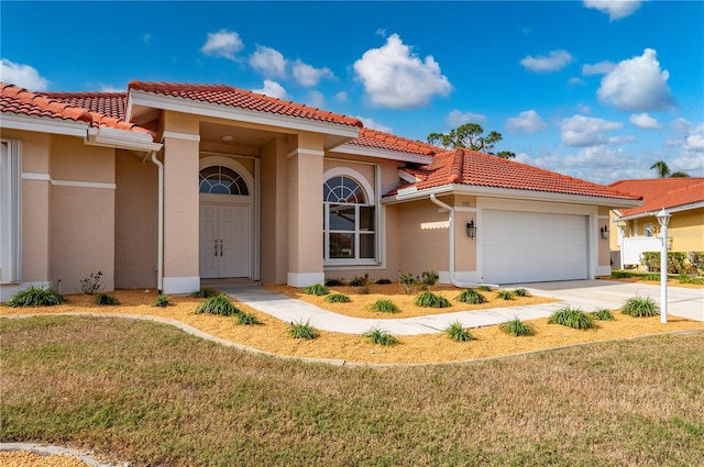 mediterranean / spanish house featuring a front lawn and a garage