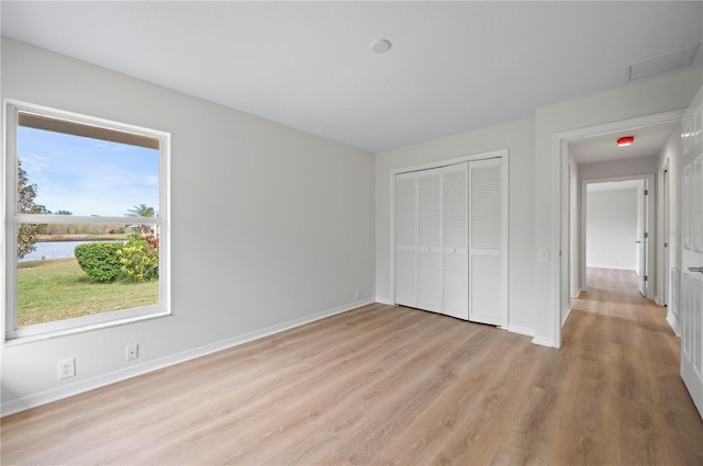 unfurnished bedroom with a closet and light hardwood / wood-style flooring